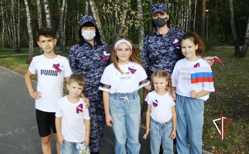 Росгвардейцы вручают жителям Тюменской области ленточки в цветах российского флага