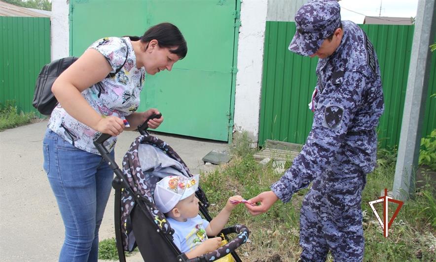 Росгвардейцы вручают жителям Тюменской области ленточки в цветах российского флага
